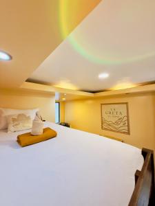 a bedroom with a bed with a rainbow on the ceiling at La Greta El Nido Apartments in El Nido