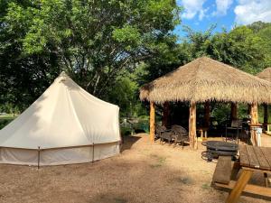 a white tent and a picnic table and a grill at Relaxation and Fun Combined Glamping Tents M & In-Water Picnic Table L in Kingsbury, TX in Second Crossing