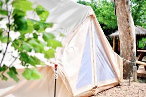 a white tent sitting next to a tree at Relaxation and Fun Combined Glamping Tents M & In-Water Picnic Table L in Kingsbury, TX in Second Crossing