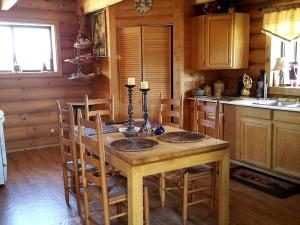 a wooden kitchen with a wooden table and chairs at Spacious, Inviting Log Cabin Encircled by Wildlife in Utah in Long Valley Junction