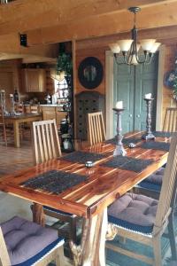 a wooden table with chairs and a dining room at Spacious, Inviting Log Cabin Encircled by Wildlife in Utah in Long Valley Junction