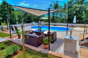 a patio with an umbrella and a swimming pool at Holiday Home Villa Lucia in Vodnjan
