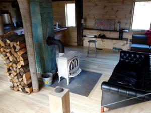 a living room with a woodburning stove in a cabin at Charming Cabin Getaway with a Wood-Burning Stove in Chesterfield, Massachusetts in South Worthington