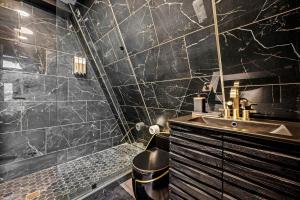 a black bathroom with a sink and a mirror at Modern A-Frame Cabin with Breathtaking Views of the Smoky Mountains, Perfect for Families or Groups in Hartford