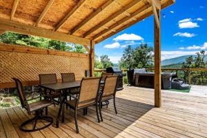 a wooden deck with a table and chairs and a grill at Modern A-Frame Cabin with Breathtaking Views of the Smoky Mountains, Perfect for Families or Groups in Hartford +82 photos
