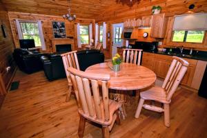 a dining room with a table and chairs in a cabin at Cozy Log Cabin near Hocking Hills State Park, Ohio in Cedar Grove