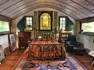 Postel nebo postele na pokoji v ubytování Eclectic Riverfront Log Cabin and Artist Retreat for Groups in Castle Hayne, North Carolina