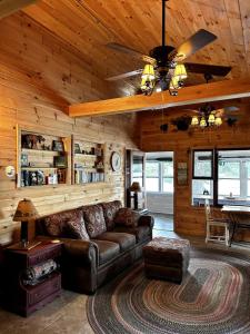 a living room with a leather couch in a cabin at Cozy Lakefront Cabin Perfect for a Family Getaway in Wells, NY in Wells
