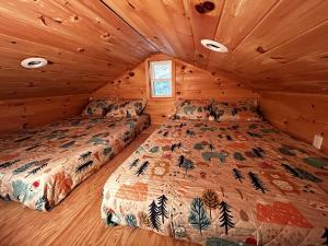 a bedroom with two beds in a cabin at Cozy Lakefront Cabin Perfect for a Family Getaway in Wells, NY in Wells