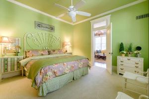 1 dormitorio verde con 1 cama y ventilador de techo en Incredible Villa Rental for Groups with Pool near Mt Vernon, Texas, en Hopewell