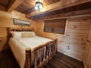 a bedroom with a bed in a log cabin at Lakeview Cabin by Tappan Lake, Perfect for Groups with Hot-Tub in Ohio in Deersville