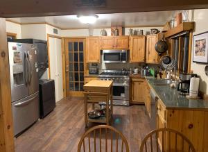a kitchen with stainless steel appliances and wooden cabinets at Waterfront Lodge Ideal for Water Activities in Wilmington, NY in Wilmington