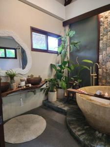 a bathroom with a large tub and potted plants at Prana Siargao Resort in General Luna +96 photos