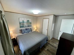 a bedroom with a bed with blue pillows on it at Unique Cottage Close to Fantastic Hiking Trails in Dunnellon, Florida in Dunnellon