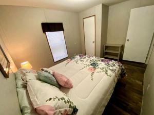 ein Schlafzimmer mit einem Bett mit einer Blumendecke darauf in der Unterkunft Unique Cottage Close to Fantastic Hiking Trails in Dunnellon, Florida in Dunnellon + 30 Fotos