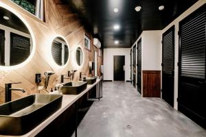 a bathroom with three sinks and a row of mirrors at Idyllic Safari Tent with Sauna and Amazing Views in North Woodstock, New Hampshire in Woodstock