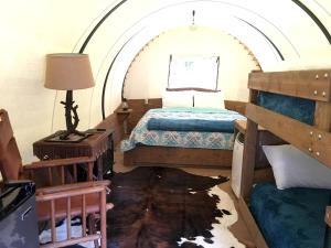 una camera con letto in una stanza ad arco di Traditional Conestoga Wagon Perfect for a Family Getaway near Zion National Park, Utah a Alton