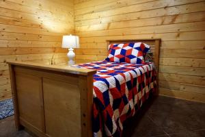 a bedroom with a bed in a wooden cabin at Spacious Log Cabin Rental for Family Vacations in Texas in Nacogdoches