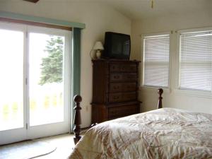 a bedroom with a bed and a television on a dresser at Cozy Lakeside Vacation Rental near St David, Maine in Lavertue