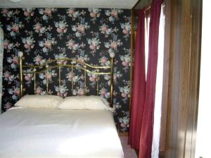 a bedroom with a bed with a floral wallpaper at Cozy Lakeside Vacation Rental near St David, Maine in Lavertue