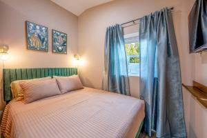 a bedroom with a bed and a window with blue curtains at Off-Grid Tiny House with Fire Pit and Countryside Views in Tennessee in Parrottsville
