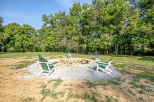 three lawn chairs sitting around a fire pit in a field at Off-Grid Tiny House with Fire Pit and Countryside Views in Tennessee in Parrottsville