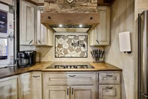 une cuisine avec un évier et un mur en pierre dans l'établissement Stunning Cabin with Games Perfect for Families in Broken Bow, Oklahoma, à Stephens Gap