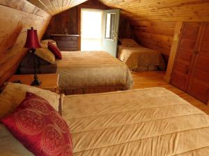- une chambre avec 3 lits dans une cabane en rondins dans l'établissement Secluded Rental Cabin with Hot Tub near Deep Creek Lake in West Virginia, à Cranesville