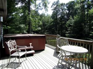 une terrasse avec un bain à remous, 2 chaises et une table dans l'établissement Secluded Rental Cabin with Hot Tub near Deep Creek Lake in West Virginia, à Cranesville