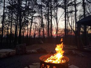 a fire pit in a yard with a sunset in the background at Fern Dell - Air Conditioned in Hot Springs National Park, Arkansas in Hot Springs +25 photos