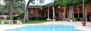 a swimming pool in front of a house at Simple and Cozy Cabin Rental on Private Ranch Retreat near Austin, Texas in Waelder