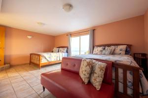 ein Schlafzimmer mit zwei Betten und einer Couch und einem Fenster in der Unterkunft Luxury Oceanfront Vacation Rental with Hot Tub near Nye Beach, Newport, Oregon in Newport