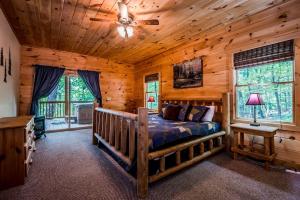 a bedroom with a bed in a log cabin at Sunrise Summit | Deluxe 2BR 2.5BA Cabin | Mountain View | Private | Hot Tub in Sautee Nacoochee, Georgia in Sautee Nacoochee