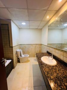 a bathroom with a sink and a toilet and a mirror at New Horizon 2 Bed Room LUXURY APARTMENT JBR in Dubai