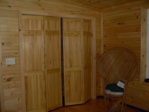a room with wooden walls and a chair in a cabin at Romantic Cabin Rental with Wi-Fi near Lake Ontario in Sackets Harbor, New York in Sackets Harbor