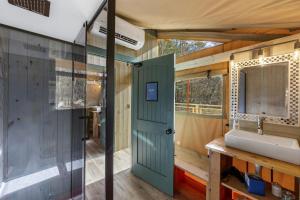 un baño en una casa pequeña con lavabo en Radiant Safari Tent Escape near Smoky Mountains in Tennessee, en Parrottsville