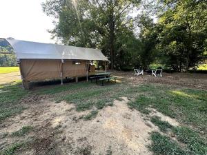 Una tienda de campaña con una mesa de picnic y sillas en un campo en Radiant Safari Tent Escape near Smoky Mountains in Tennessee, en Parrottsville 23 fotos más