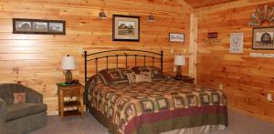 a bedroom with a bed and a chair in a cabin at Luxury Cabin for Great Weekend Trips in Maryland in Flintstone