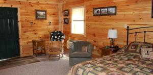 a bedroom with a bed and a chair in a cabin at Luxury Cabin for Great Weekend Trips in Maryland in Flintstone