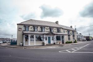 a white building on the corner of a street at Bay View Hotel in Kilkee