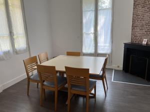 a dining room with a white table and chairs at Hébergements le Camp d'Auneau - Aunay Bien in Auneau