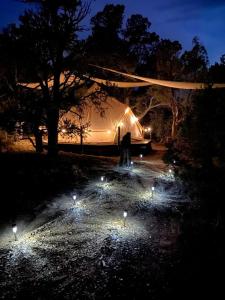 una persona de pie frente a una tienda de campaña por la noche en Secluded Bell Tent Nestled in the Pines in Duchesne, Utah, en Fruitland