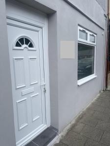 a white door and a window on a building at Flat in Maerdy in Maerdy +1 photo