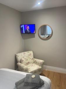 a room with a chair and a tv on the wall at Flat in Maerdy in Maerdy