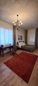 ein Schlafzimmer mit einem Bett, einem Tisch und einem roten Teppich in der Unterkunft Ava House Taş Oda 1 in Diyarbakır