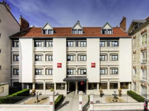 un gran edificio blanco con techo rojo en ibis Besançon Centre Ville, en Besançon
