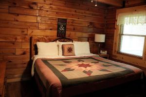 a bedroom with a bed in a log cabin at Rustic Cabin Rental in the Wilderness near Beckley, West Virginia in Hico