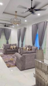 コタバルにあるQaseh homestayのリビングルーム(ソファ2台、天井ファン付)