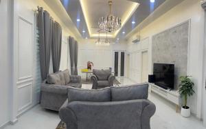 コタバルにあるQaseh homestayのリビングルーム(ソファ2台、テレビ付)