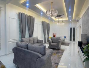 コタバルにあるQaseh homestayのリビングルーム(ソファ2台、シャンデリア付)